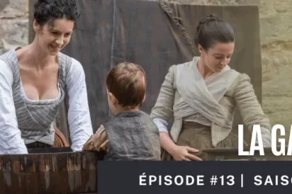 Claire souriante participe à la lessive avec Jenny et le petit Jamie, dans la cour du domaine de Lallybroch – scène domestique paisible dans l’épisode 13.