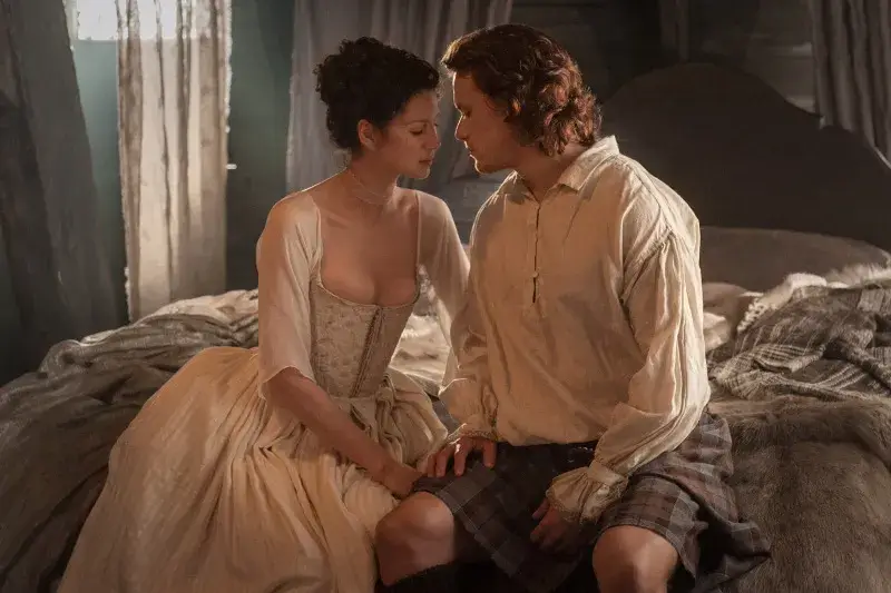 Claire et Jamie Fraser échangent un regard complice et amoureux le soir de leur mariage, scène culte d’Outlander saison 1.