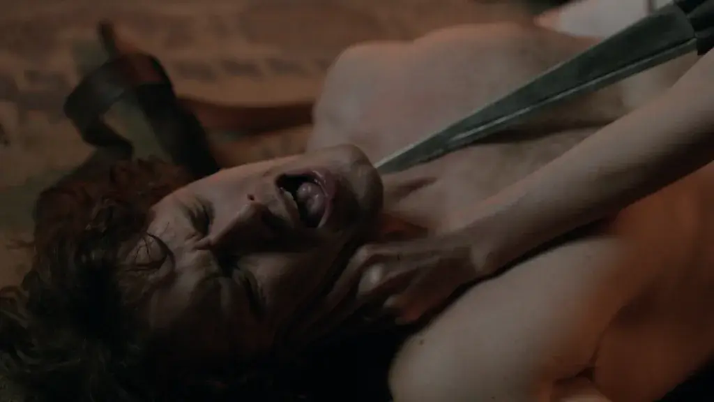 Jamie Fraser, torse nu, Claire le menace de son poignard lors d'une scène intime. - Saison 1 épisode 9