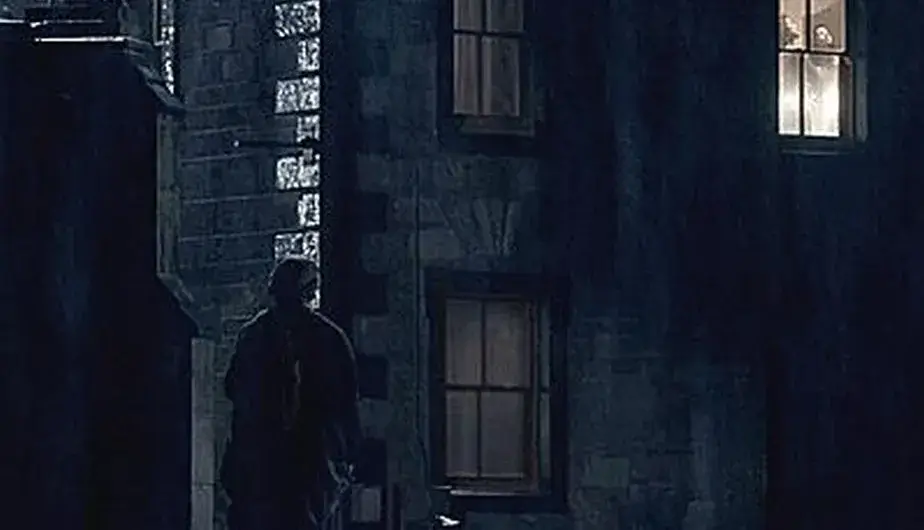 Silhouette mystérieuse devant une maison écossaise, illustrant la scène culte du fantôme de Jamie observant Claire à travers la fenêtre dans la série Outlander.
