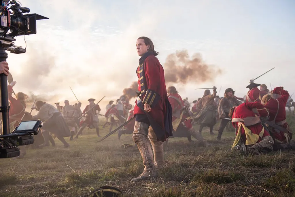 Black Jack Randall au milieu du champs de bataille fait face à la caméra. Image de tournage. - Outlander saison 3 épisode 1 "A chacun son combat"