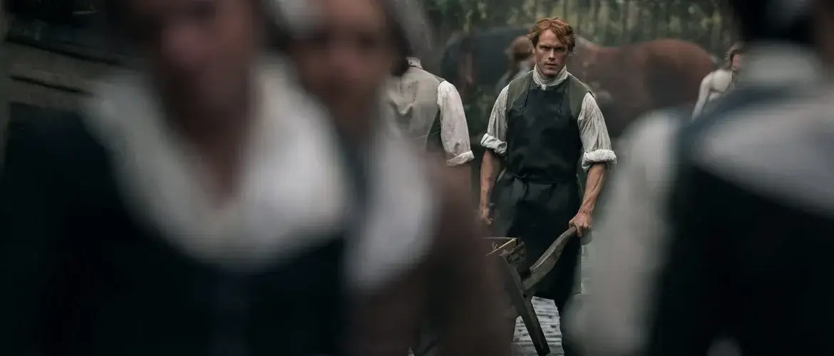 Jamie transportant du fumier dans une brouette. - Outlander saison 3 épisode 4.
